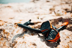 snorkel-and-diving-scuba-mask-on-a-rock-near-the-sea-picjumbo-com